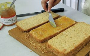 Lamingtons Rezept: Konfitüre auf Kuchenschichten verteilen
