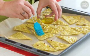 Selbstgemachte Nachos Rezept: Dreiecke mit Öl einpinseln