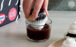 Schaumkuss-Cupcakes Rezept: Cupcakes in Glasur tunken